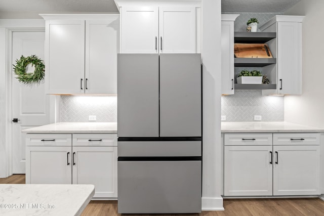 kitchen featuring white cabinets, light wood-type flooring, and open shelves