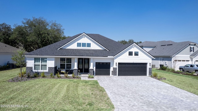 view of front of property featuring central air condition unit, stone siding, decorative driveway, and a front yard