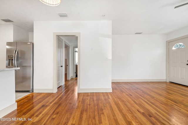 interior space featuring visible vents, baseboards, and wood finished floors