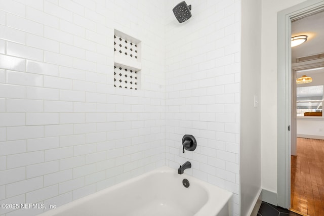 bathroom featuring shower / washtub combination and baseboards