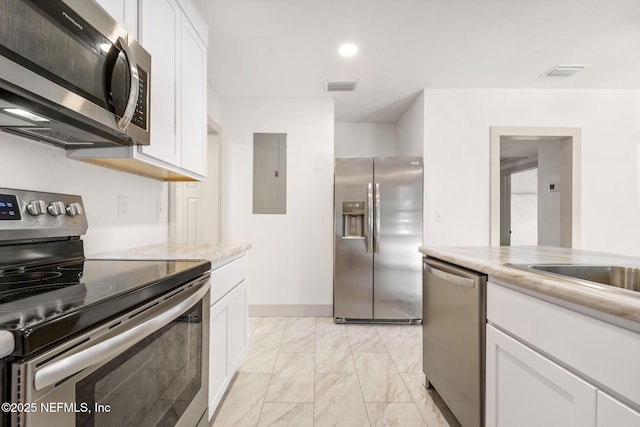 kitchen featuring marble finish floor, stainless steel appliances, visible vents, and white cabinetry