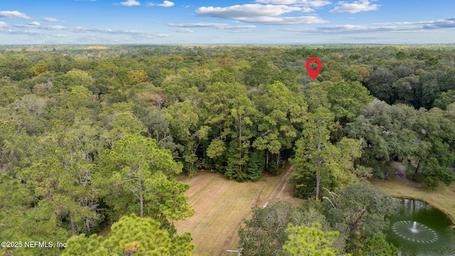 drone / aerial view featuring a water view and a forest view