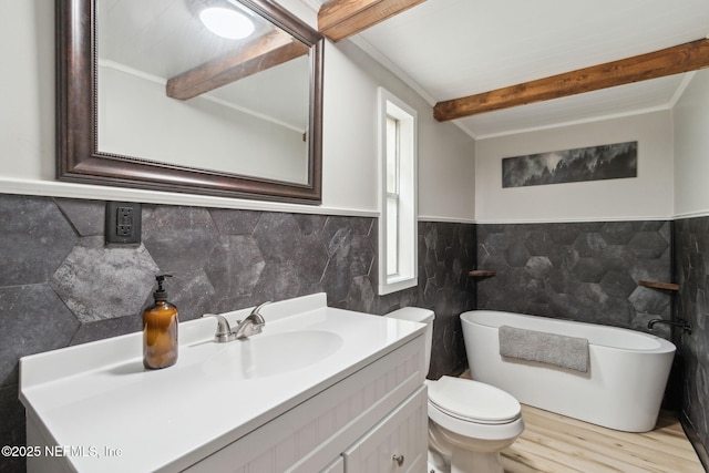 bathroom with wood finished floors, vanity, tile walls, a freestanding bath, and beamed ceiling