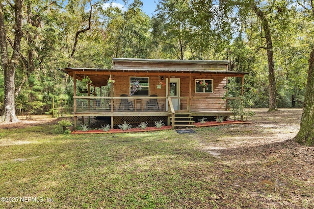 rustic home featuring covered porch and a front yard