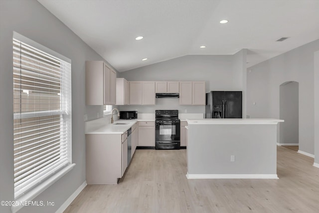 kitchen with a sink, white cabinetry, light countertops, black appliances, and light wood finished floors