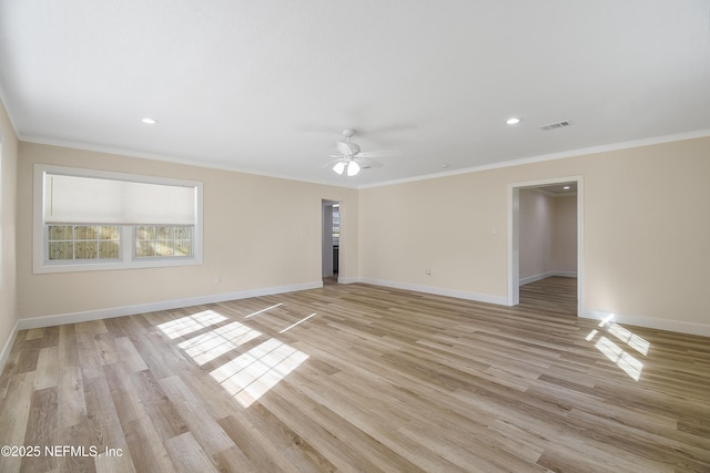 spare room featuring light wood finished floors, baseboards, visible vents, ceiling fan, and ornamental molding