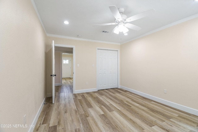 unfurnished bedroom with crown molding, a closet, visible vents, light wood-style flooring, and baseboards