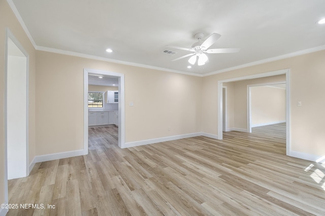 spare room featuring visible vents, crown molding, light wood-style flooring, and baseboards