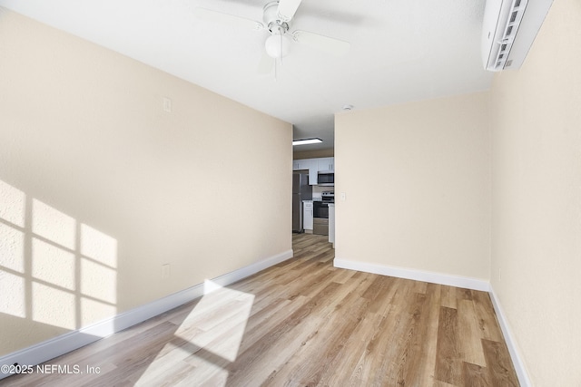 unfurnished room with ceiling fan, light wood-style flooring, and baseboards