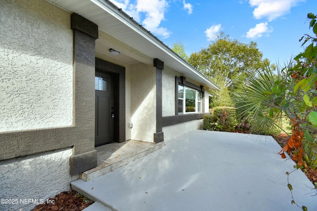 doorway to property with a patio and stucco siding