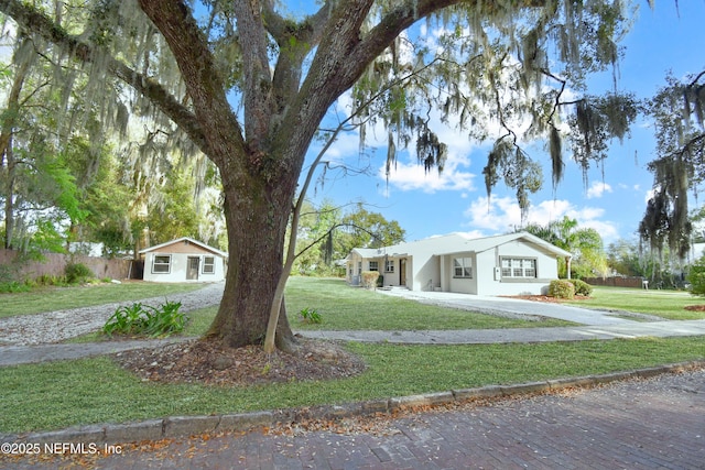 ranch-style house featuring a front yard and fence