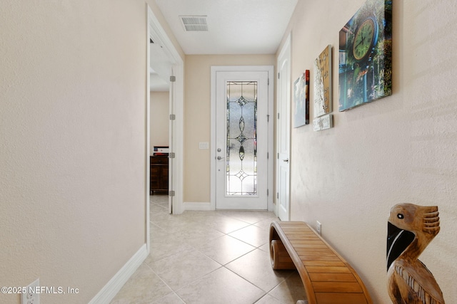 doorway to outside featuring light tile patterned floors, visible vents, and baseboards