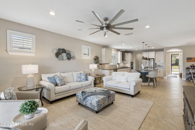 living room with a healthy amount of sunlight, light tile patterned floors, a ceiling fan, and recessed lighting