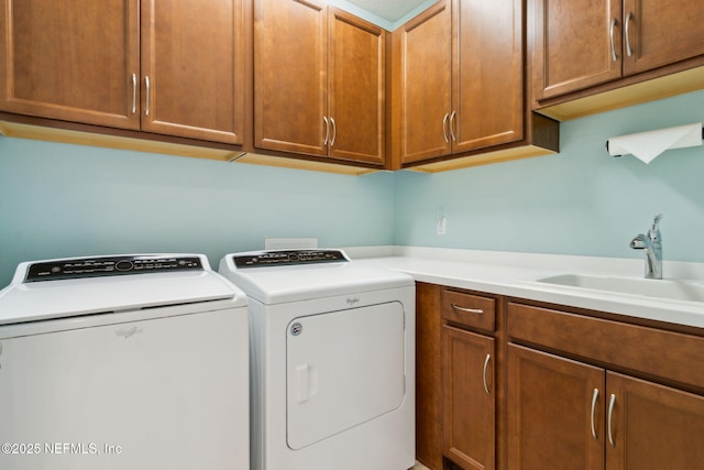 washroom featuring cabinet space, separate washer and dryer, and a sink