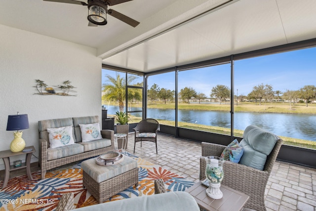 sunroom / solarium featuring a ceiling fan and a water view