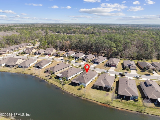 aerial view featuring a forest view, a water view, and a residential view