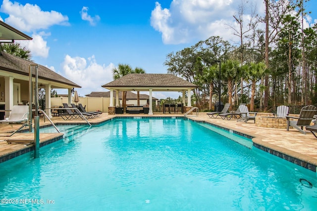 pool with an outdoor fire pit, fence, a patio, and a gazebo