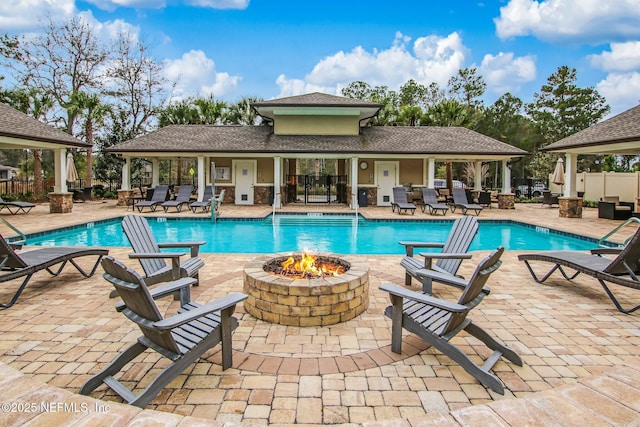 community pool featuring a fire pit, a gazebo, a patio area, and fence