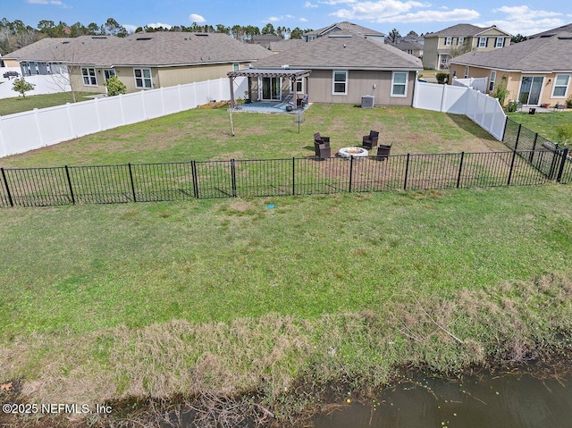 view of yard with an outdoor fire pit, a fenced backyard, a water view, a residential view, and a pergola