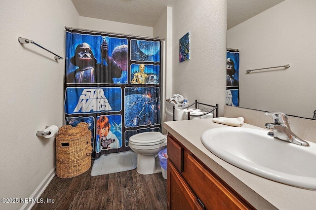 bathroom with a textured ceiling, toilet, wood finished floors, vanity, and a shower with curtain