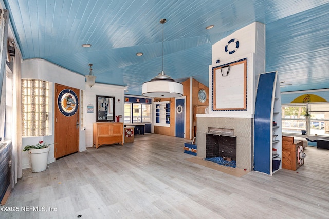 living room with lofted ceiling, a fireplace, wood finished floors, and wooden ceiling