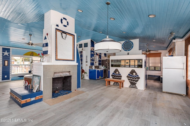 living area with wooden ceiling, vaulted ceiling, wood finished floors, and a tile fireplace