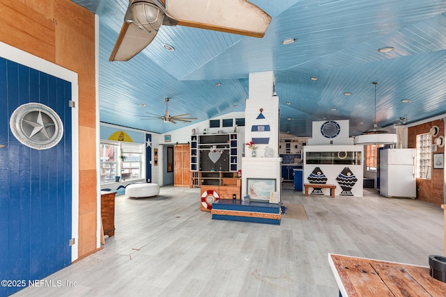 interior space featuring a ceiling fan, vaulted ceiling, and wood finished floors