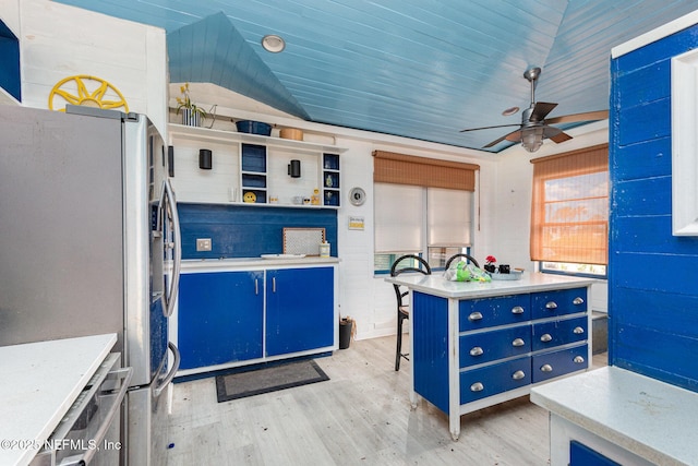 kitchen with open shelves, blue cabinetry, stainless steel refrigerator with ice dispenser, and light countertops