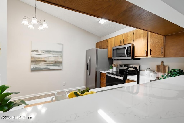 kitchen featuring lofted ceiling, appliances with stainless steel finishes, brown cabinets, decorative light fixtures, and light countertops