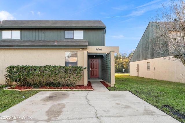 entrance to property with a patio and a yard