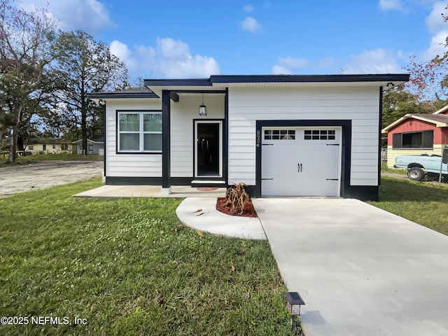 view of front of property featuring an attached garage, driveway, and a front lawn