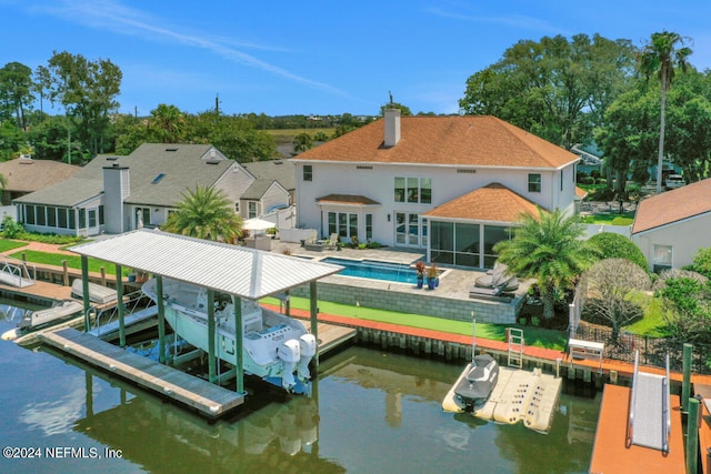 dock area with an outdoor pool, a water view, a patio, and boat lift