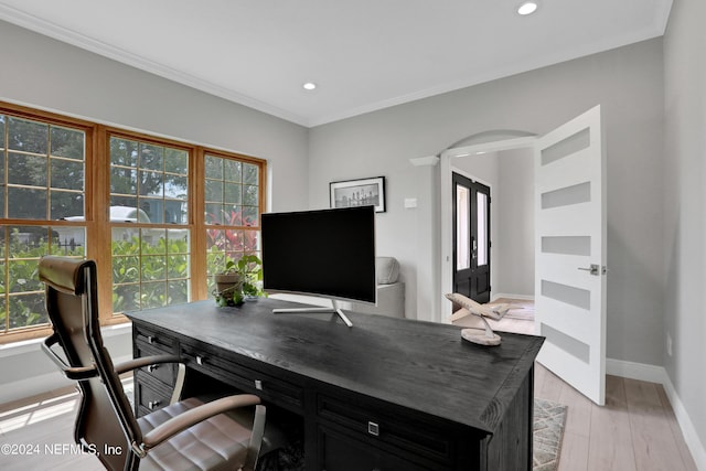 office featuring a wealth of natural light, arched walkways, baseboards, and light wood finished floors