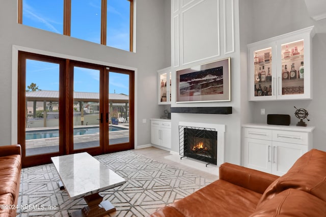 living room featuring a lit fireplace and a towering ceiling