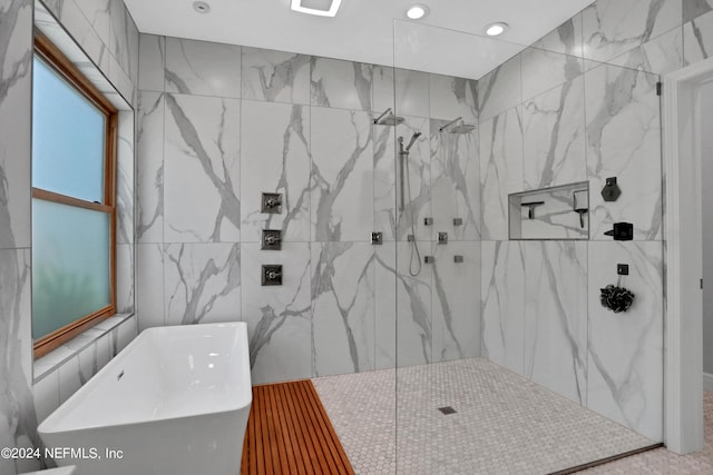 full bathroom with a freestanding tub, a marble finish shower, and tile walls