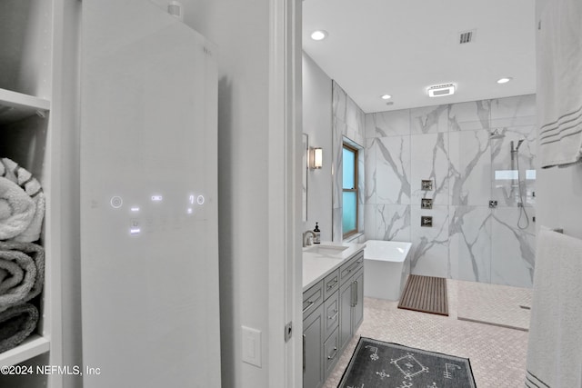 bathroom featuring visible vents, a soaking tub, walk in shower, and tile walls