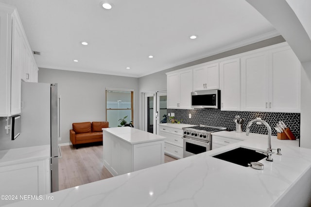 kitchen featuring appliances with stainless steel finishes, white cabinetry, and light stone countertops