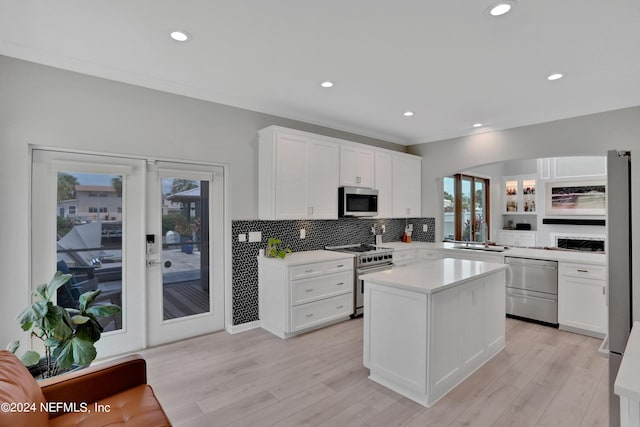 kitchen featuring white cabinets, light wood-style flooring, stainless steel appliances, light countertops, and french doors