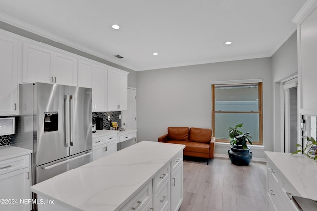 kitchen featuring ornamental molding, white cabinets, stainless steel fridge, and decorative backsplash