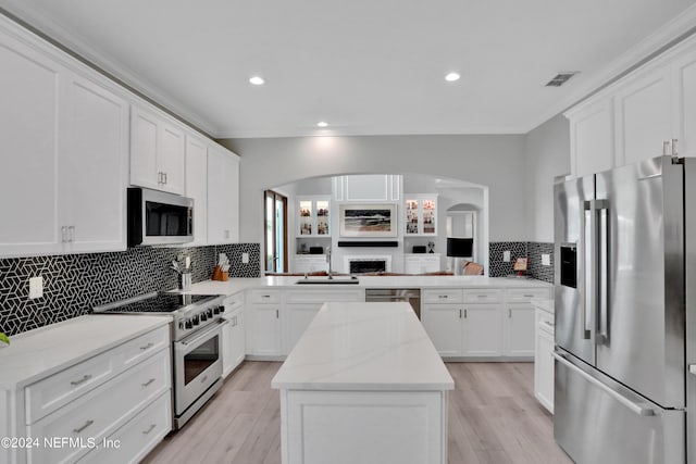 kitchen featuring stainless steel appliances, visible vents, a peninsula, and white cabinetry