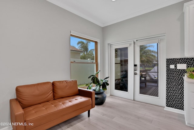 interior space with light wood finished floors, plenty of natural light, crown molding, and french doors