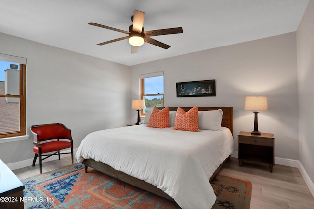 bedroom featuring ceiling fan, light wood finished floors, and baseboards