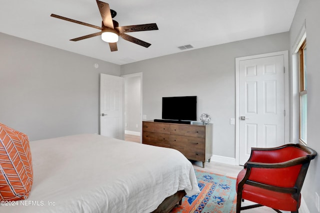 bedroom with ceiling fan, baseboards, visible vents, and light wood-style flooring