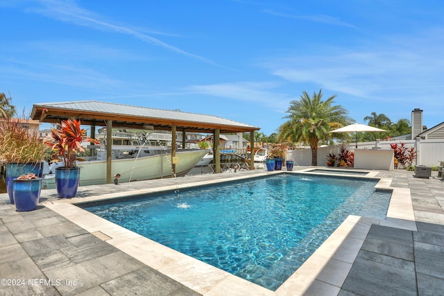 view of swimming pool featuring a patio area, fence, a fenced in pool, and an in ground hot tub