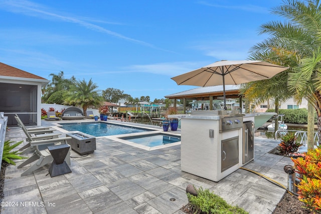 view of swimming pool with a bar, an in ground hot tub, a sunroom, and area for grilling