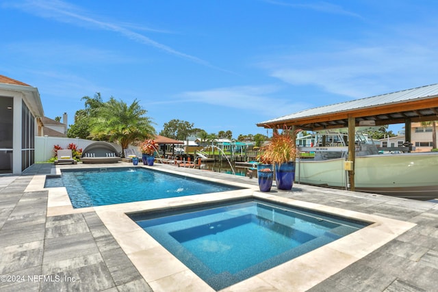 view of pool featuring a water view, fence, a fenced in pool, and an in ground hot tub