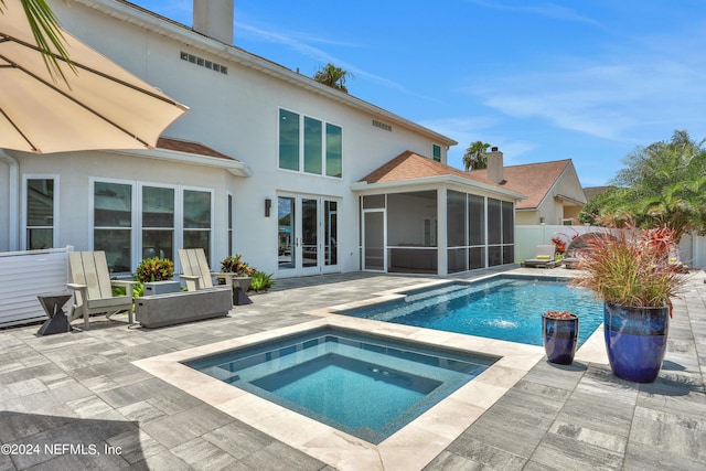 rear view of property with a fenced in pool, a sunroom, an in ground hot tub, fence, and french doors