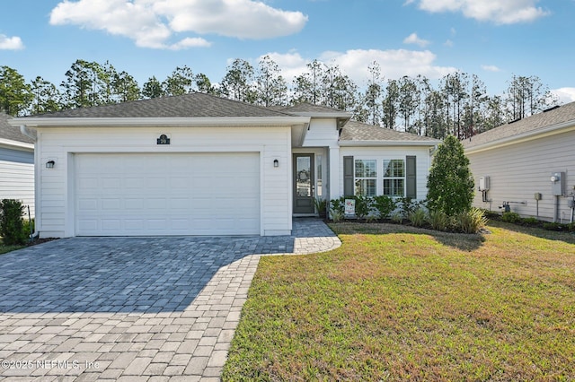 single story home with an attached garage, a front lawn, and decorative driveway