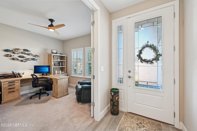 carpeted entryway with baseboards and a ceiling fan