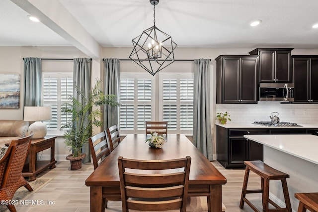 dining area with light wood-style floors, a notable chandelier, and recessed lighting